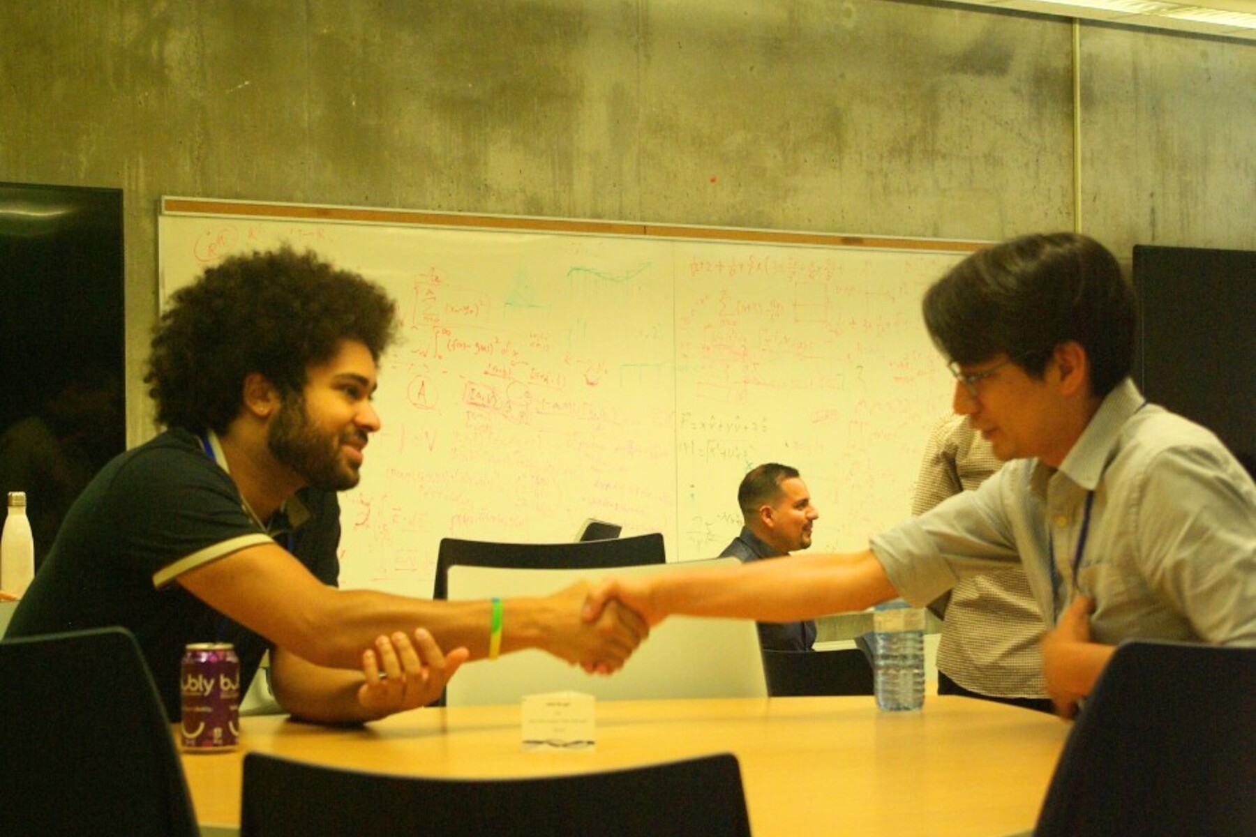 two people shake hands across a table