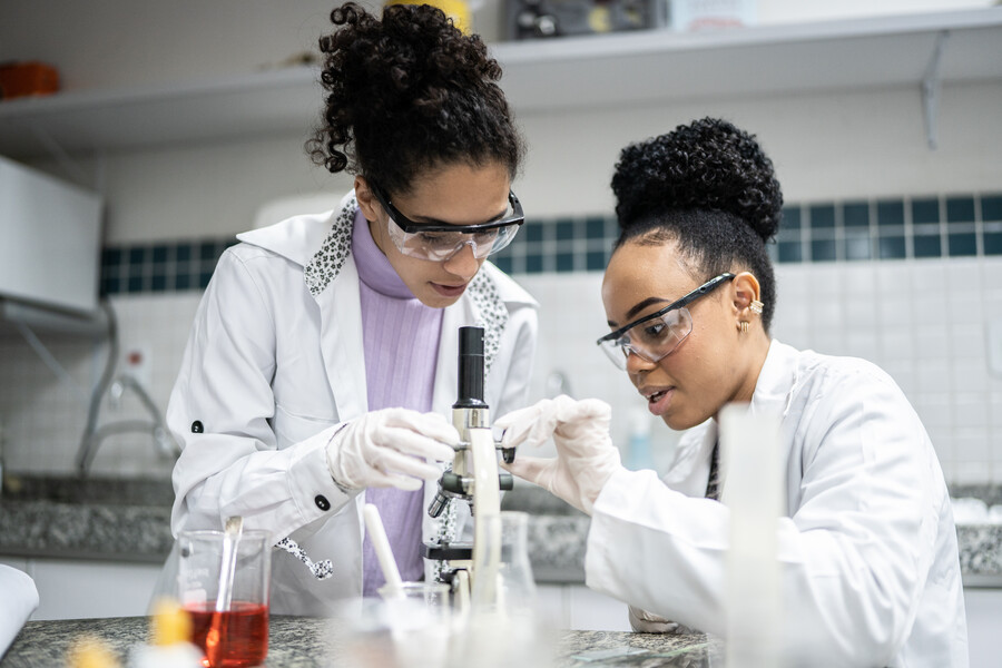 Two researchers work at a lab bench.